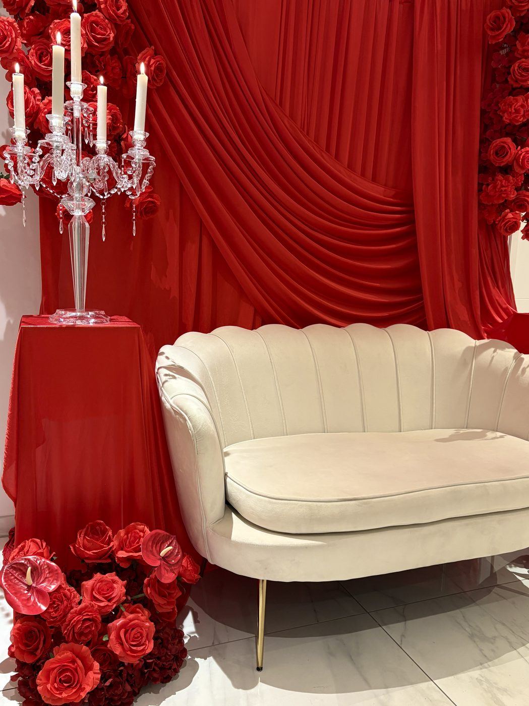 Trône drapé rouge floral, chandelier et fleurs